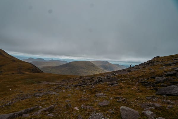 Views from Carrauntoohil A climber hiking up Carrauntoohil with views across the Macgillycuddy's Reeks in the background.