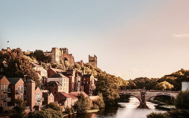 A gorgeous sepia-toned photograph of Durham City, with the bridge and river featuring prominently and Durham Cathedral in the background.
